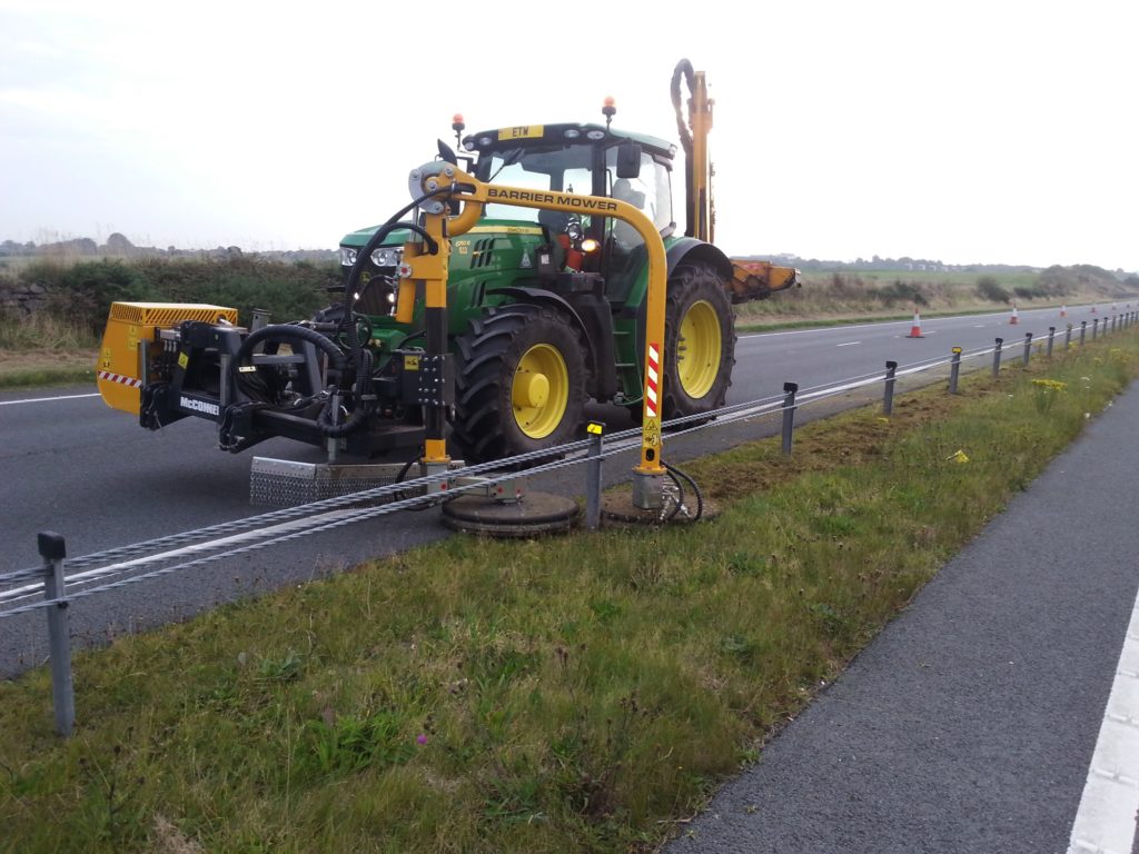 A tractor with a barrier mower cutting grass on the A55