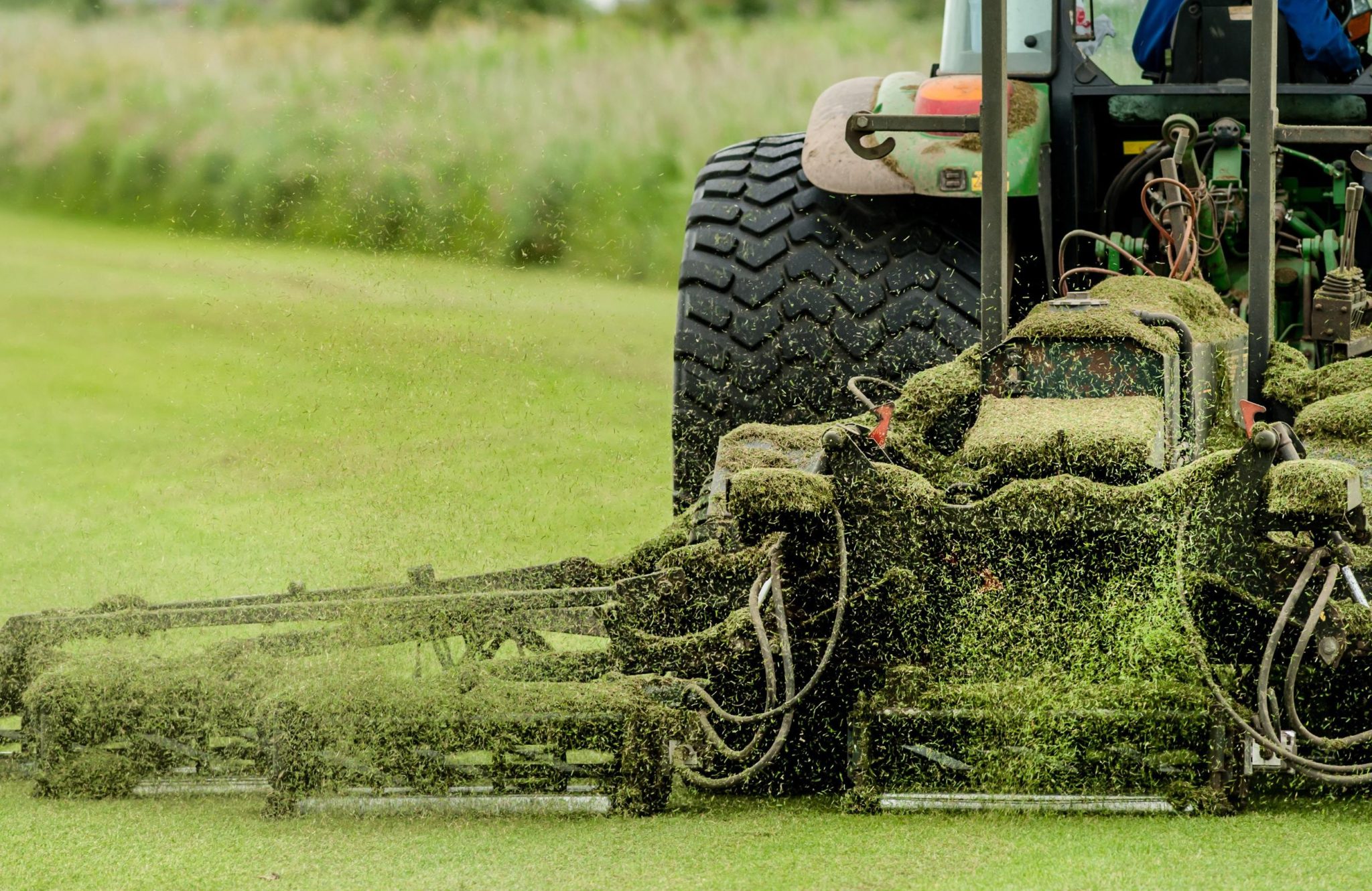 A tractor with an attached mower cutting grass